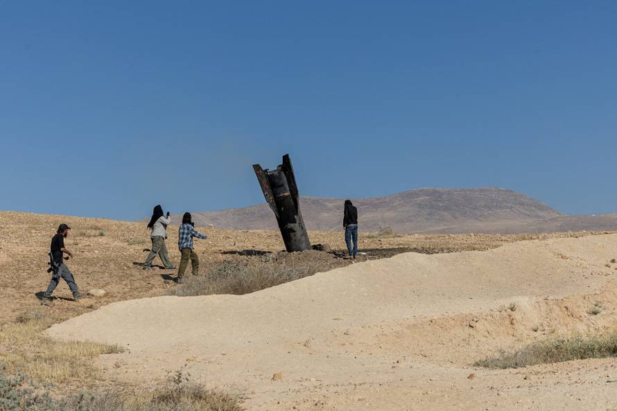Part of a missile launched from protrudes from the ground, in the central Israeli-occupied West Bank