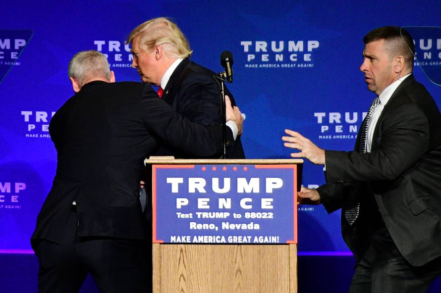 Donald Trump is hustled off the stage by security agents in Reno
