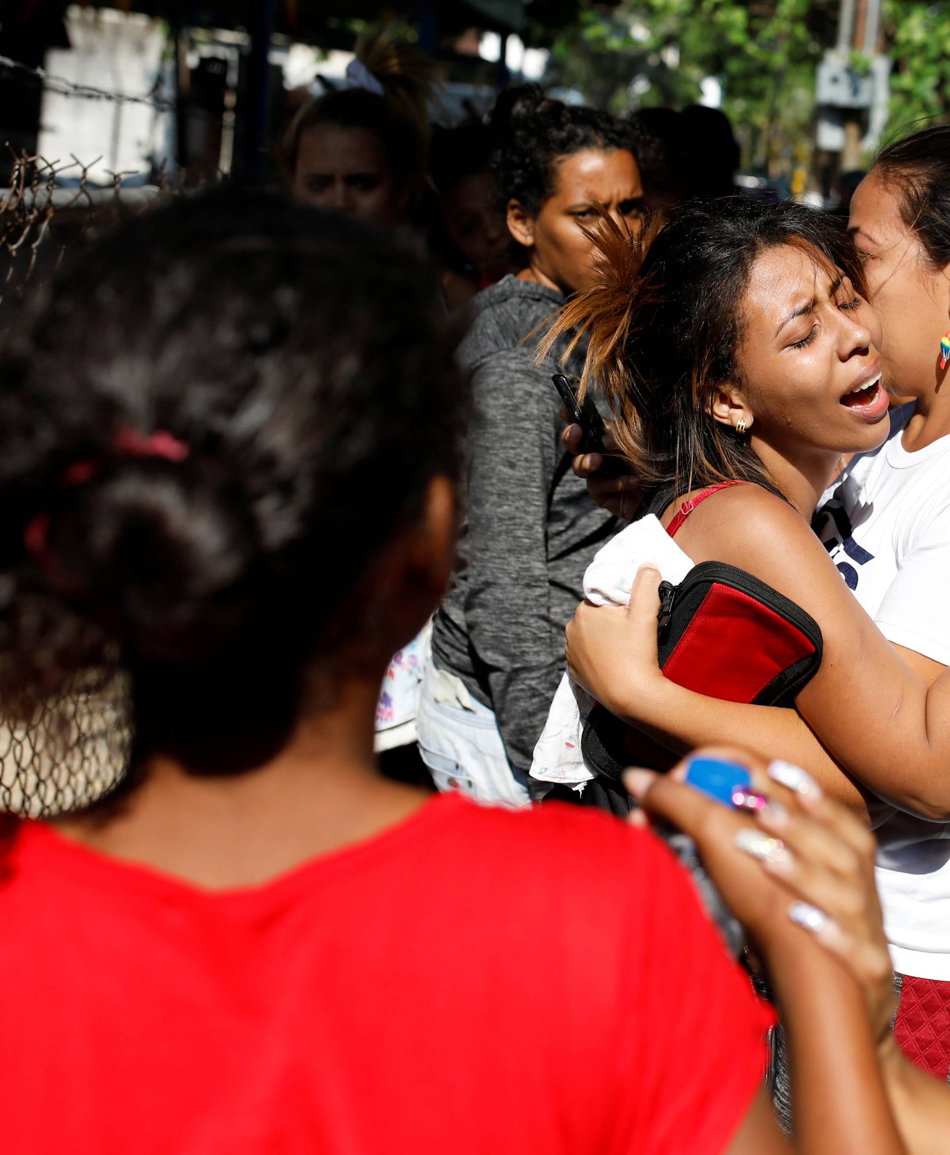Relatives of inmates at the General Command of the Carabobo Police react as they wait outside the prison in Valencia