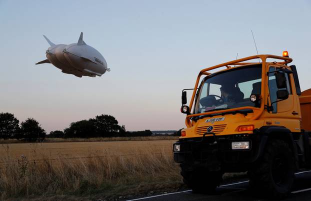 A man watches from a lorry as the Airlander 10 hybrid airship makes its maiden flight at Cardington Airfield in Britain