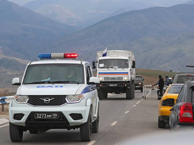 Vehicles of Russian peacekeepers leaving Nagorno-Karabakh region pass an Armenian checkpoint near Kornidzor