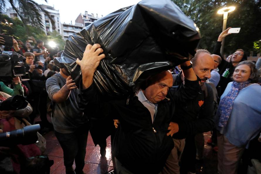 A  man holds ballots at a polling station for the banned independence referendum in Barcelona