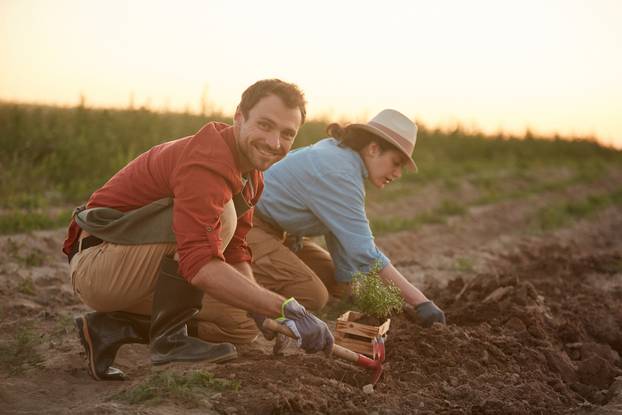 Full,Length,Portrait,Of,Two,People,Working,In,Field,At