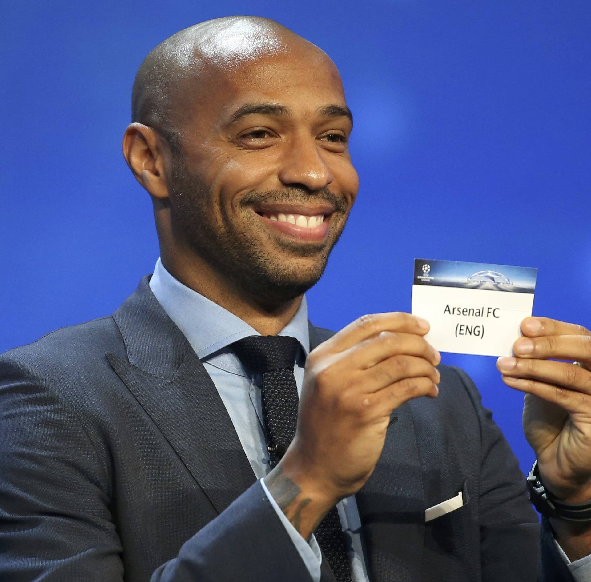 Former soccer player Thierry Henry holds a paper with the name of Arsenal FC during the draw ceremony for the 2016/2017 Champions League Cup soccer competition at Monaco's Grimaldi Forum in Monaco