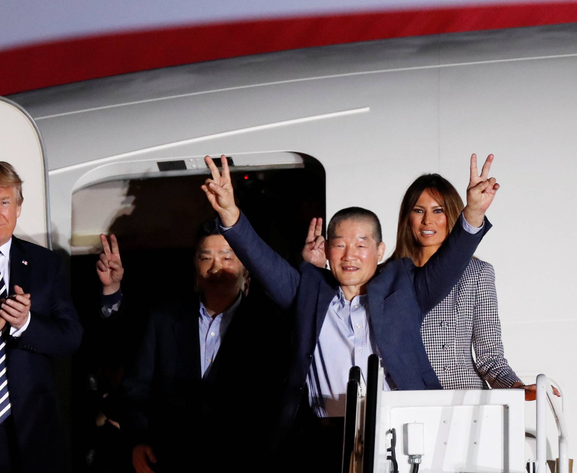 Two of the Americans formerly held hostage in North Korea gesture next to U.S.President Donald Trump and first lady Melania Trump, upon their arrival at Joint Base Andrews