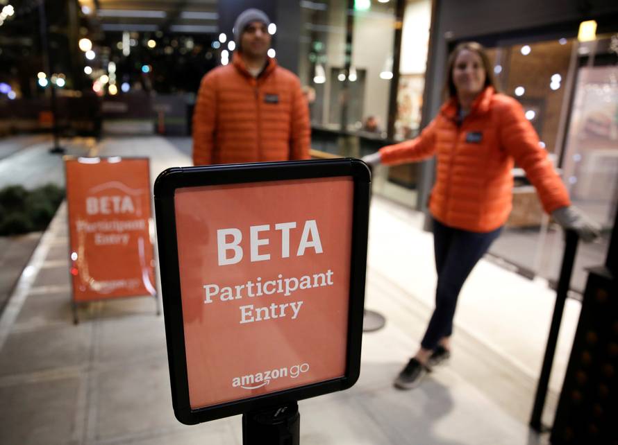 Amazon employees are pictured outside the Amazon Go brick-and-mortar grocery store without lines or checkout counters, in Seattle Washington