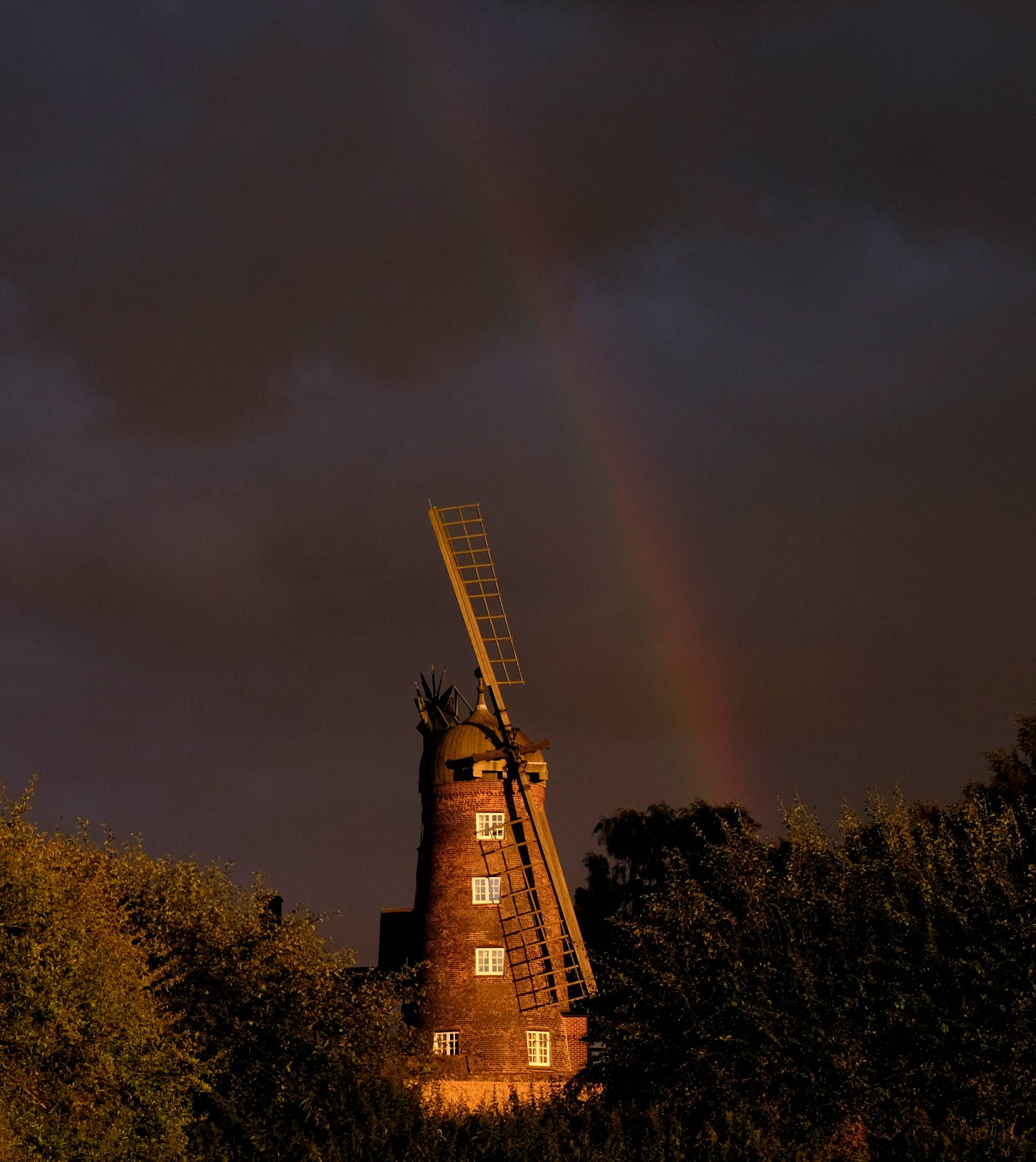 A rainbow forms over a windmill after rainfall in Shepshed