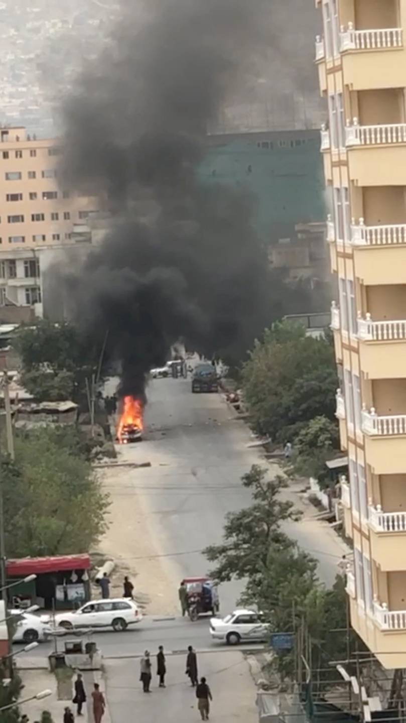 A view of remnants of flames from cars where rockets towards Kabul's international airport were fired from but were intercepted by a missile defense system in Kabul