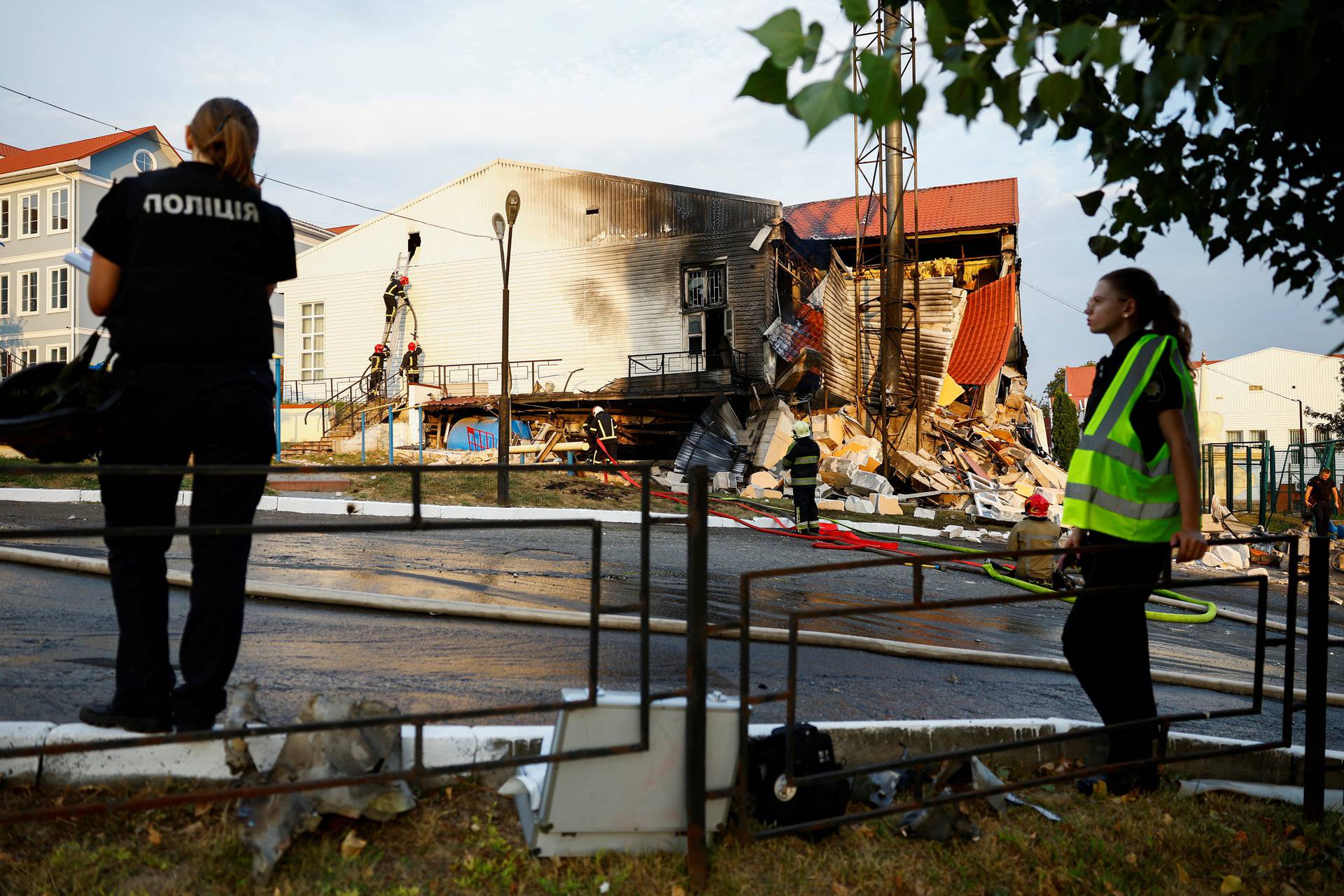 Firefighters work at a site of a sports complex of a university damaged during a Russian missile strike in Kyiv