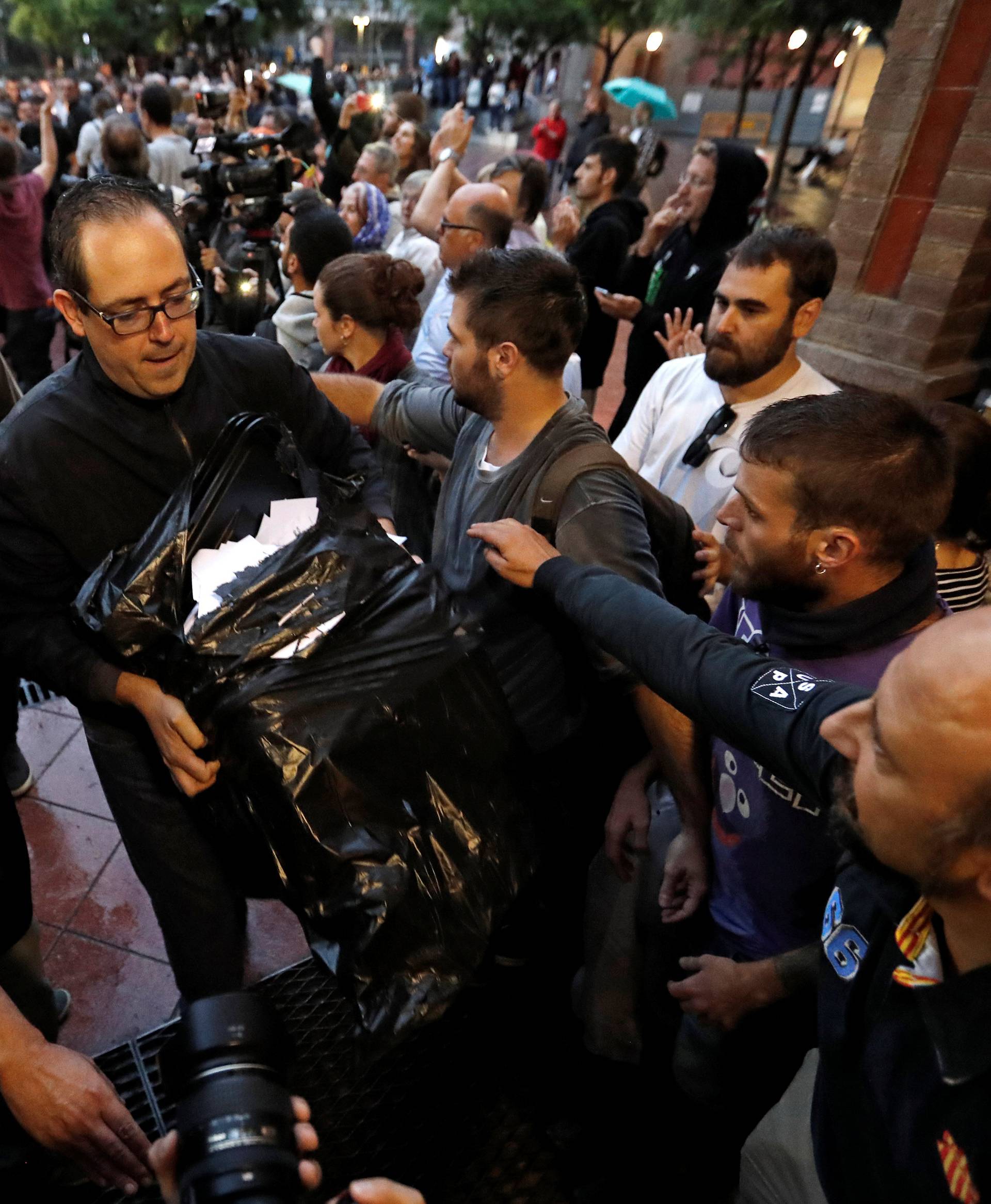 A  man holds ballots at a polling station for the banned independence referendum in Barcelona