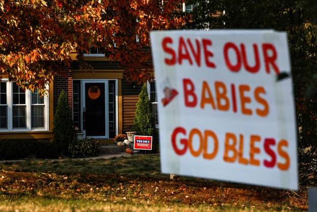 FILE PHOTO: Competing yard signs for and against Amendment 3, a measure that would establish a constitutional right to abortion dot neighborhoods in Missouri