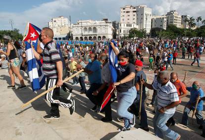 Government supporters walk during protests against and in support of the government, in Havana