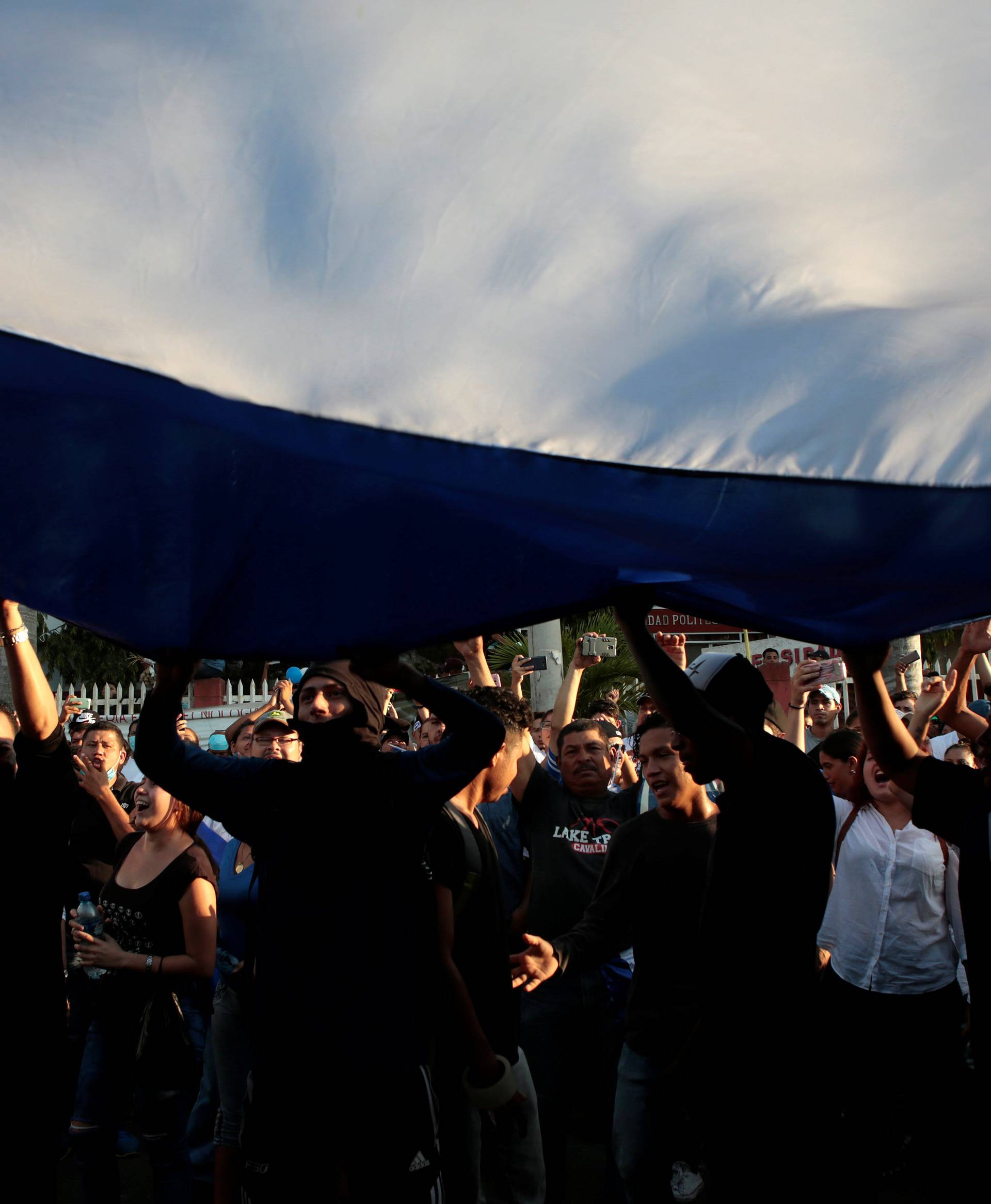 Demonstrators hold up a large Nicaraguan flag during a protest against police violence and the government of Nicaraguan President Daniel Ortega in Managua