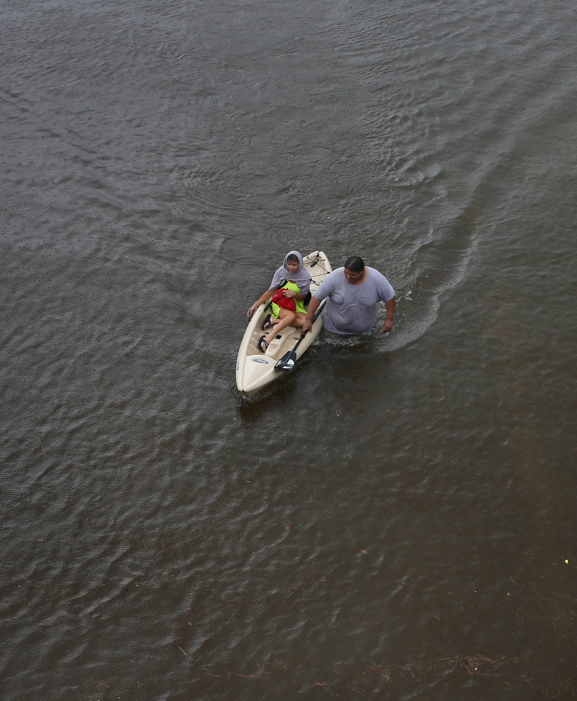 Jesus Rodriguez rescues Gloria Garcia after rain from Hurricane Harvey flooded Pearland, in the outskirts of Houston, Texas