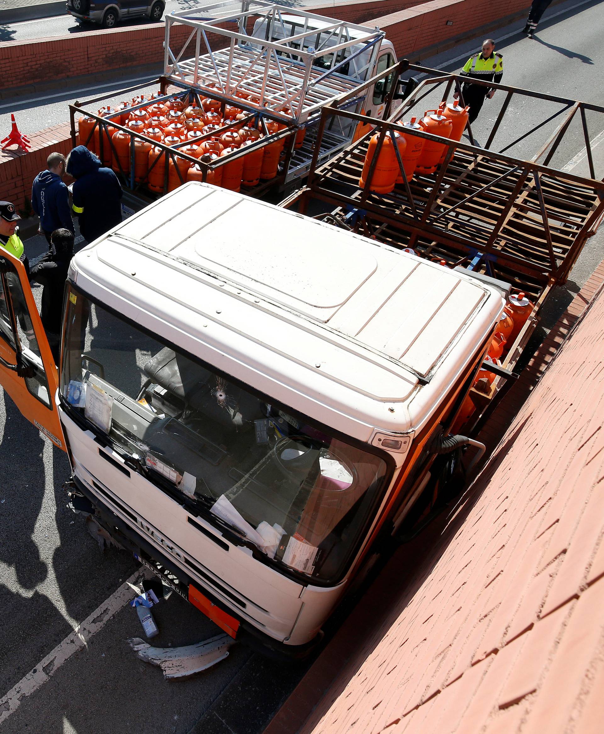 Police work at the scene of a gas cylinder delivery truck with bullet holes in its windscreen after police fired shots to stop the driver, whom they say had stolen the truck and was driving against traffic, in Barcelona, Spain