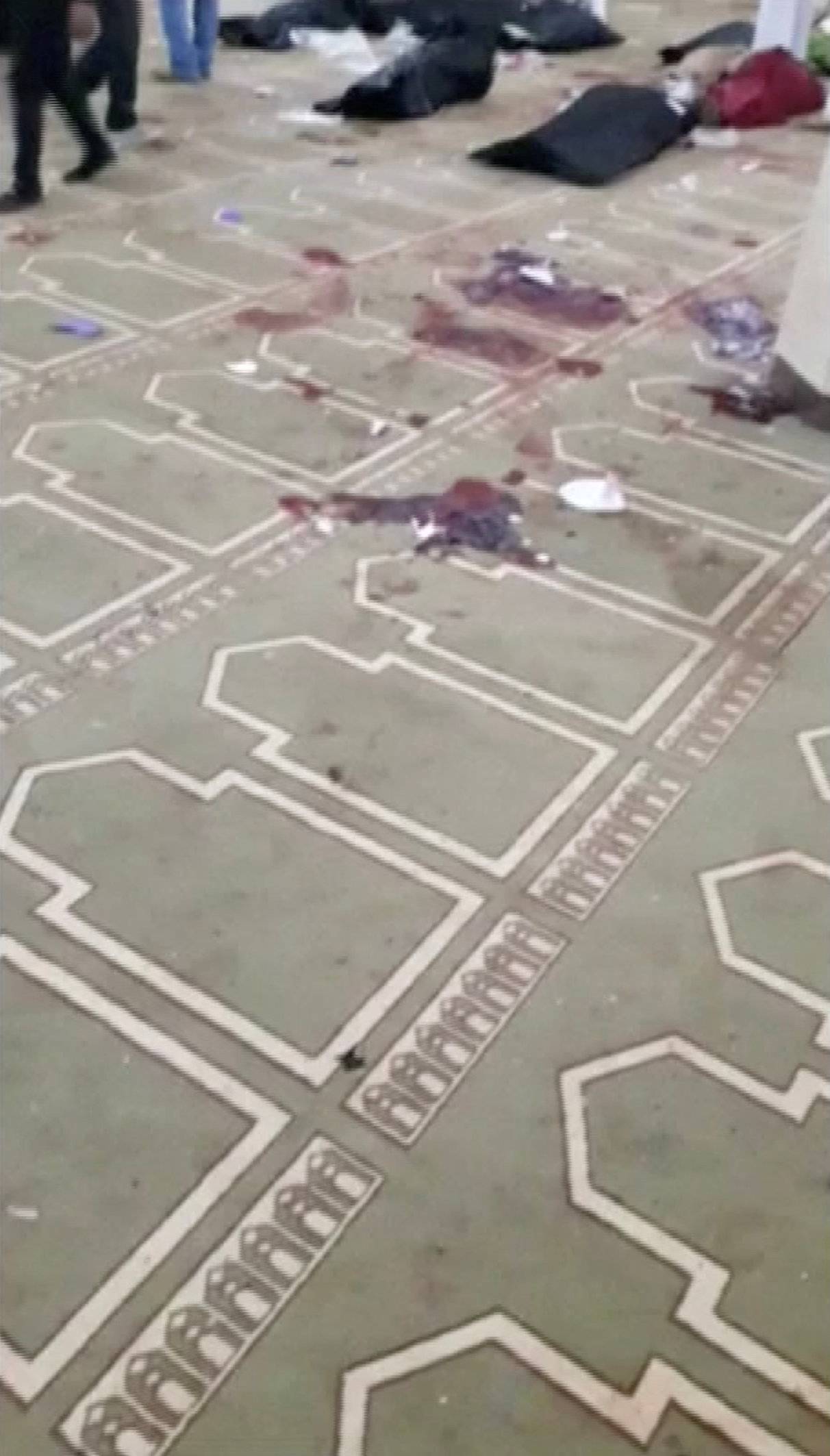 Blood is seen on the carpet inside Al Rawdah mosque in Bir Al-Abed