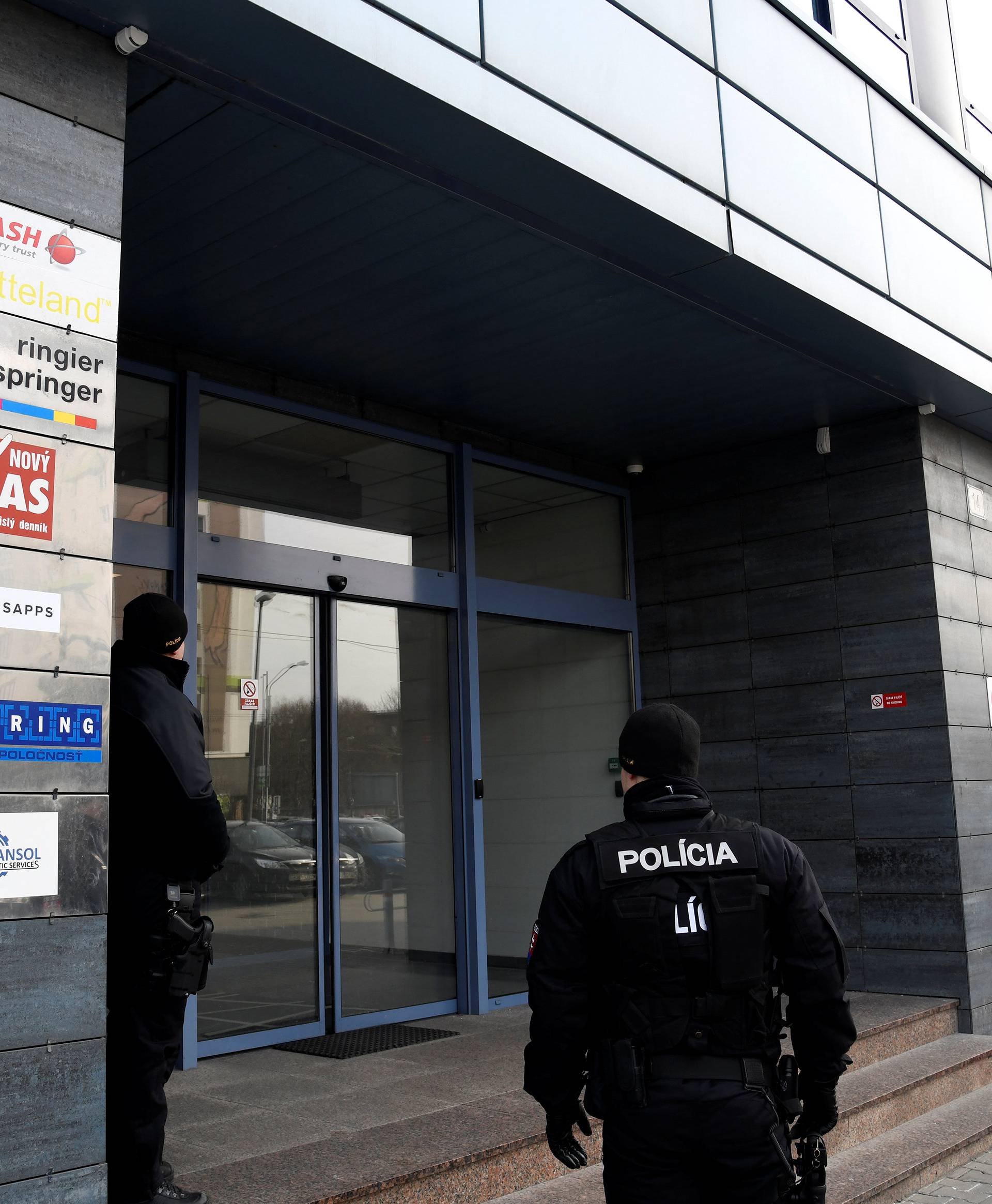Police officers guard the entrance to the head office of news website Aktuality.sk, where murdered Slovak investigative reporter Jan Kuciak was employed, at Slovak National Uprising Square in Bratislava