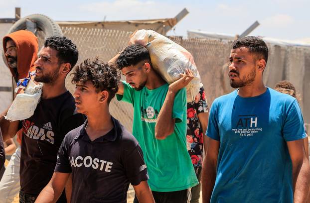 Palestinians carry aid supplies they received from the U.S.-backed Gaza Humanitarian Foundation, in Khan Younis