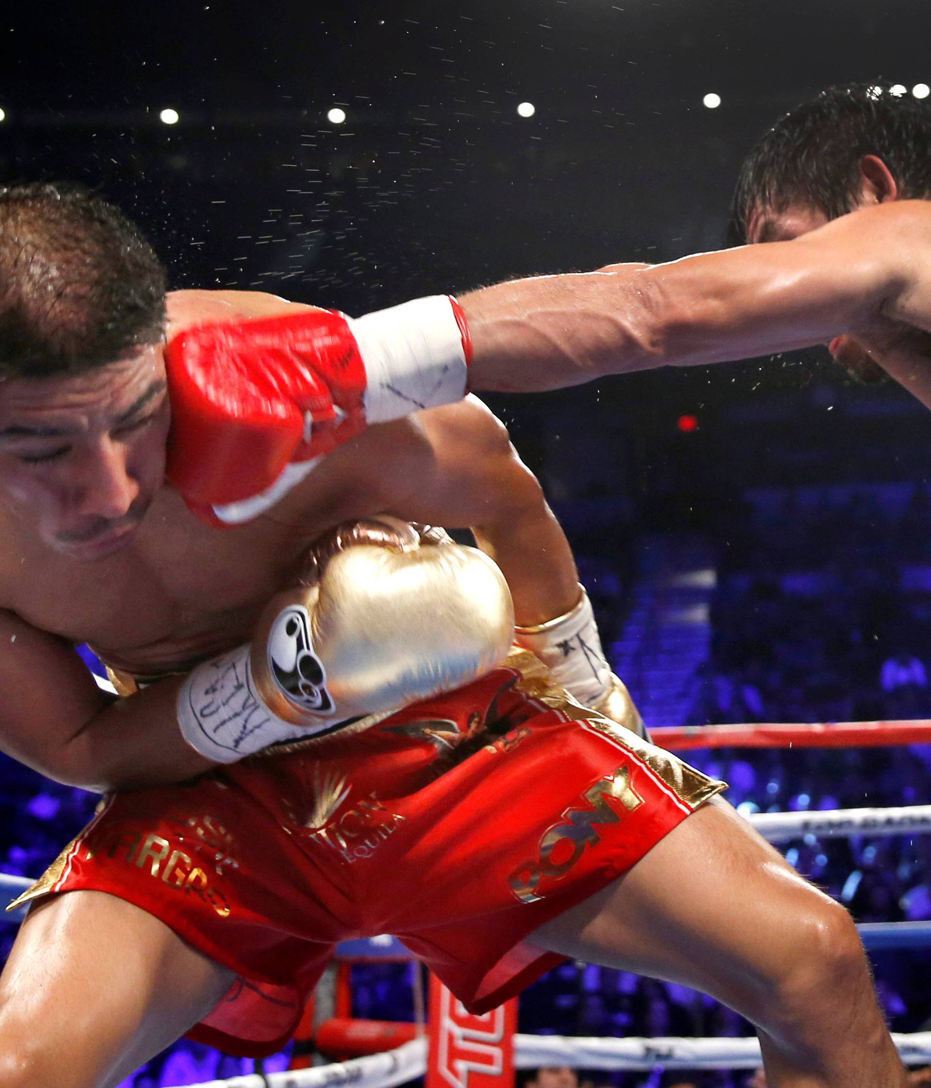 WBO welterweight champion Jessie Vargas (L) of Las Vegas gets hit with a jab from Manny Pacquiao of the Philippines during their title fight at the Thomas & Mack Center in Las Vegas