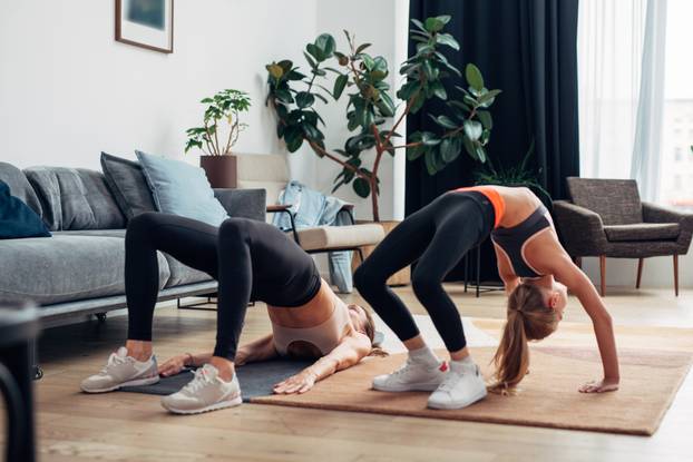 Home workout mother and daughter do bridge and gluteal bridge