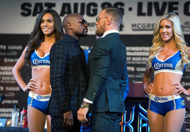 Undefeated boxer Floyd Mayweather Jr. (L) of the U.S. and UFC lightweight champion Conor McGregor of Ireland face off during a news conference in Las Vegas