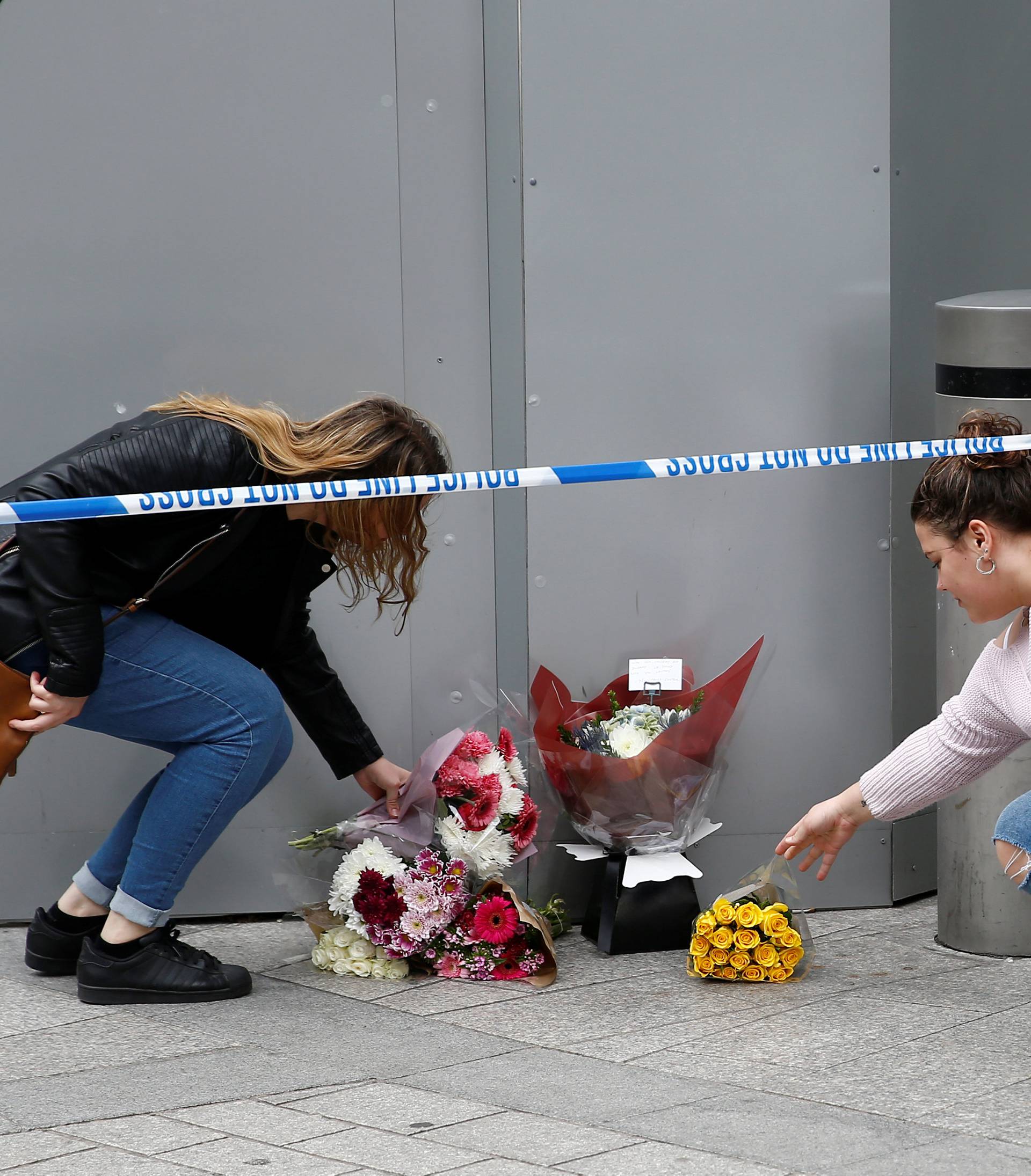 Women leave flowers near Borough Market after an attack left 7 people dead and dozens injured in London