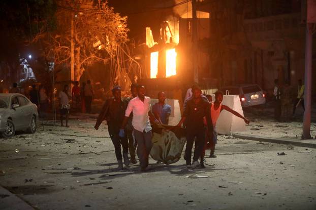 Rescue workers evacuate an injured man from the scene where a suicide car bomb exploded targeting a Mogadishu hotel in a business center at Maka Al Mukaram street in Mogadishu