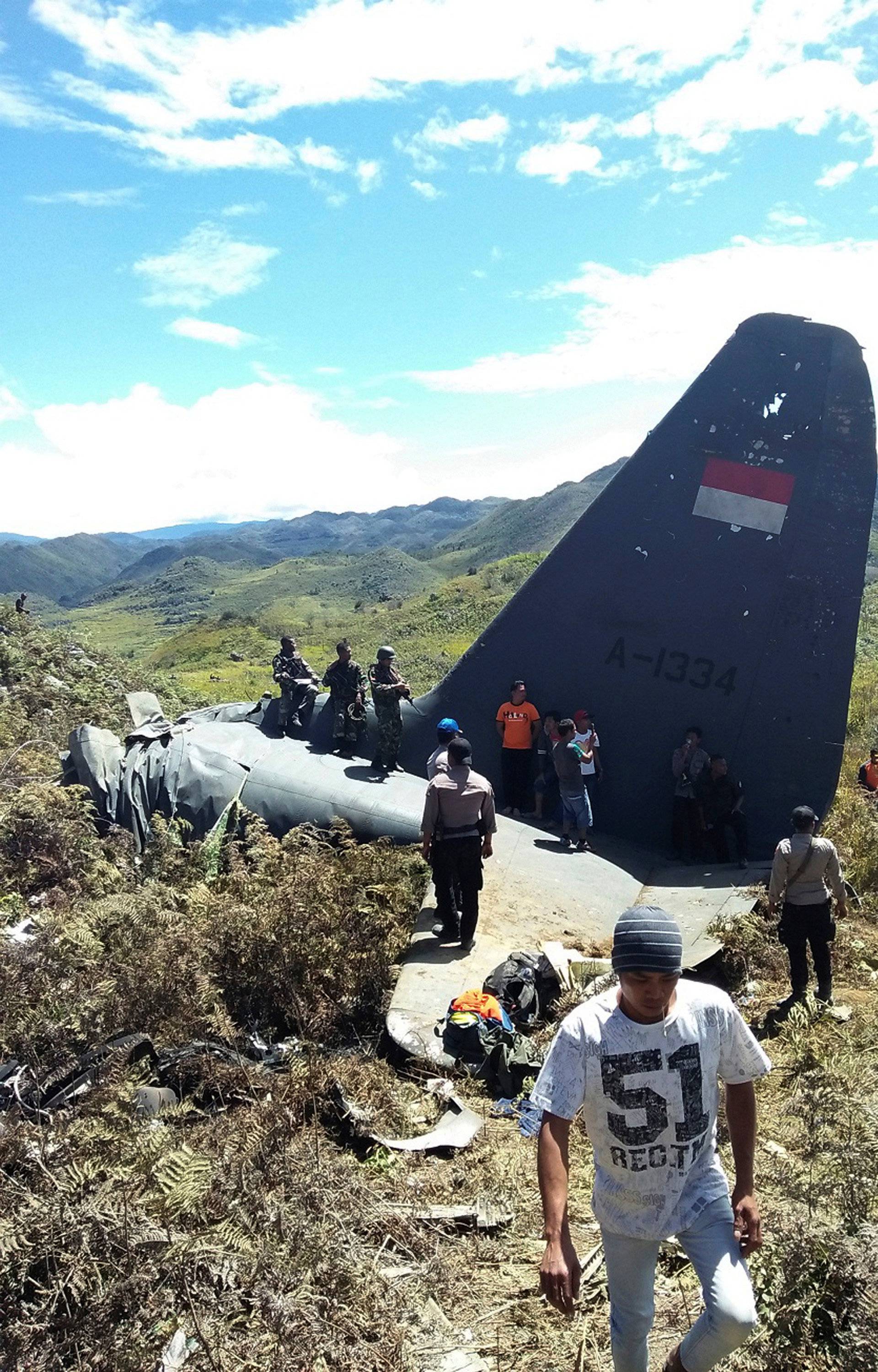 Rescue teams and locals are seen at the crash site of Indonesian air force transport plane which killed all 13 people aboard, on Mount Lisuwa, near Wamena in the remote region of Papua, Indonesia