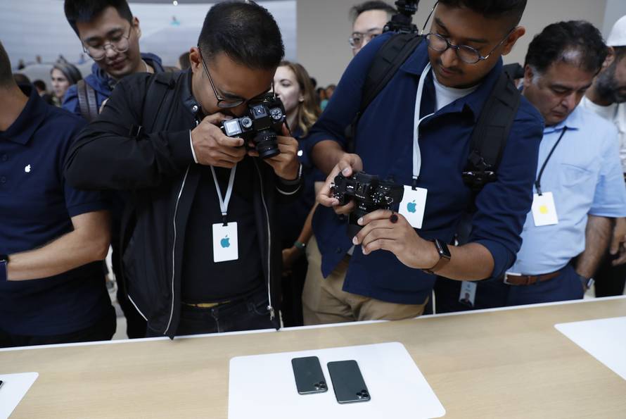 People take photos of new iPhones in the demonstration room at an Apple event at their headquarters in Cupertino