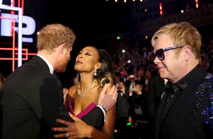 Britain's Prince Harry kisses Beverley Knight as Elton John looks on, after the Royal Variety Performance at the Albert Hall in London