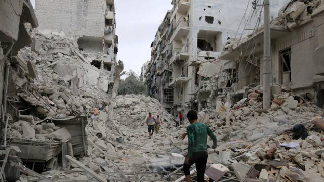 People inspect a damaged site after airstrikes on the rebel held Tariq al-Bab neighbourhood of Aleppo