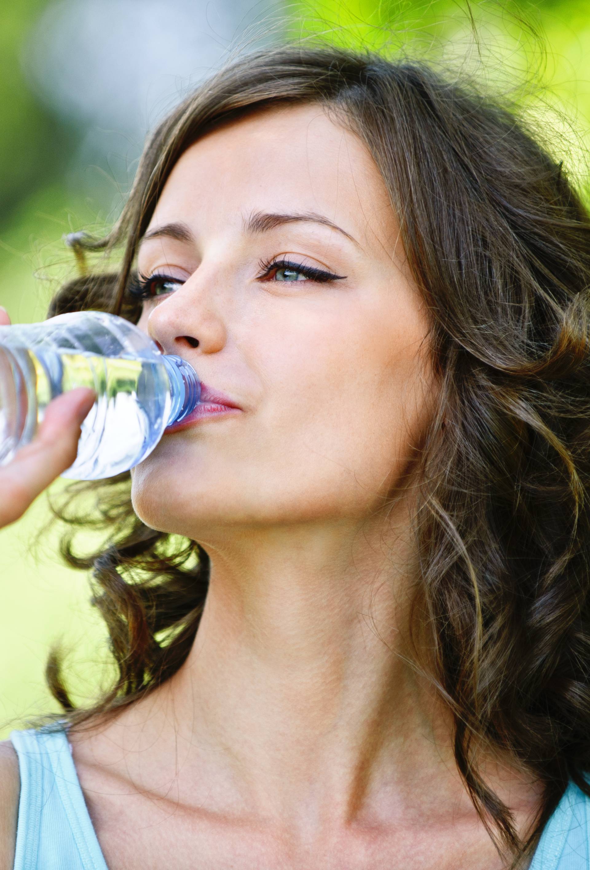 young dark-haired woman drinking water