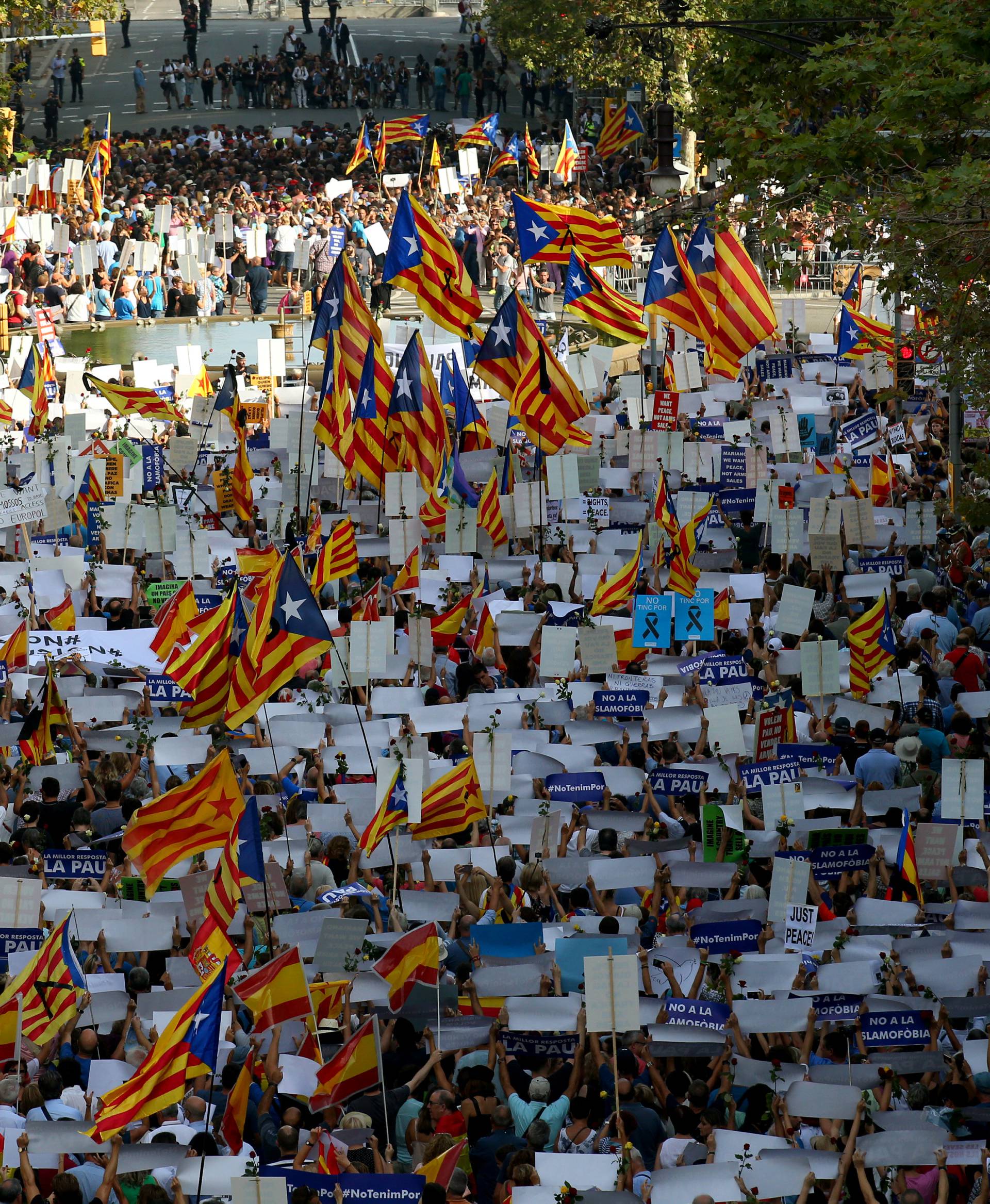 People hold placards and flag as they take part in a march of unity after the attacks last week, in Barcelona, Spain