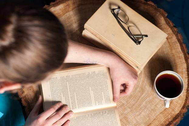 girl with a Cup of tea and book on table