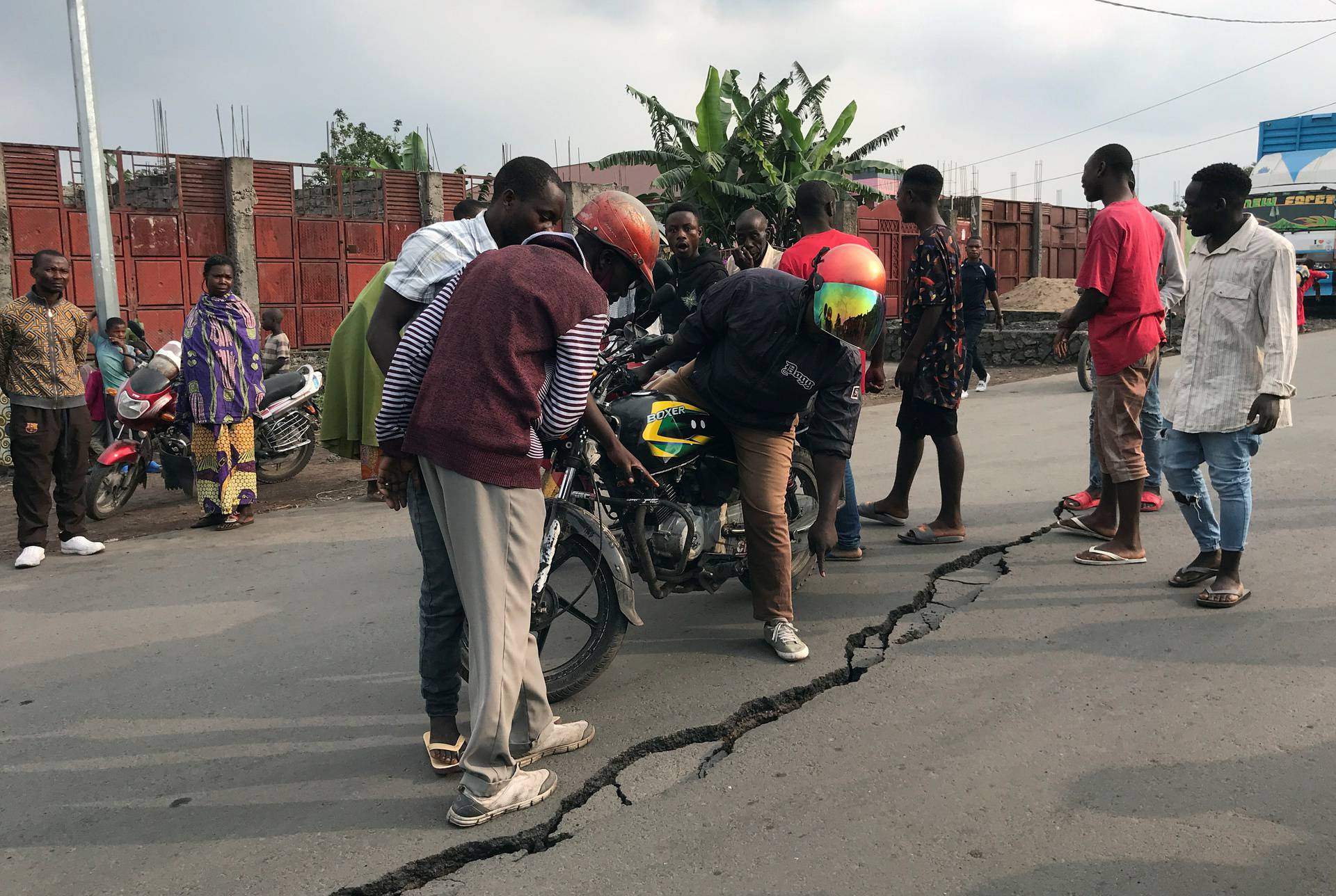 People look at a crack on the road caused by earth tremors as aftershocks following the eruption of Mount Nyiragongo volcano near Goma