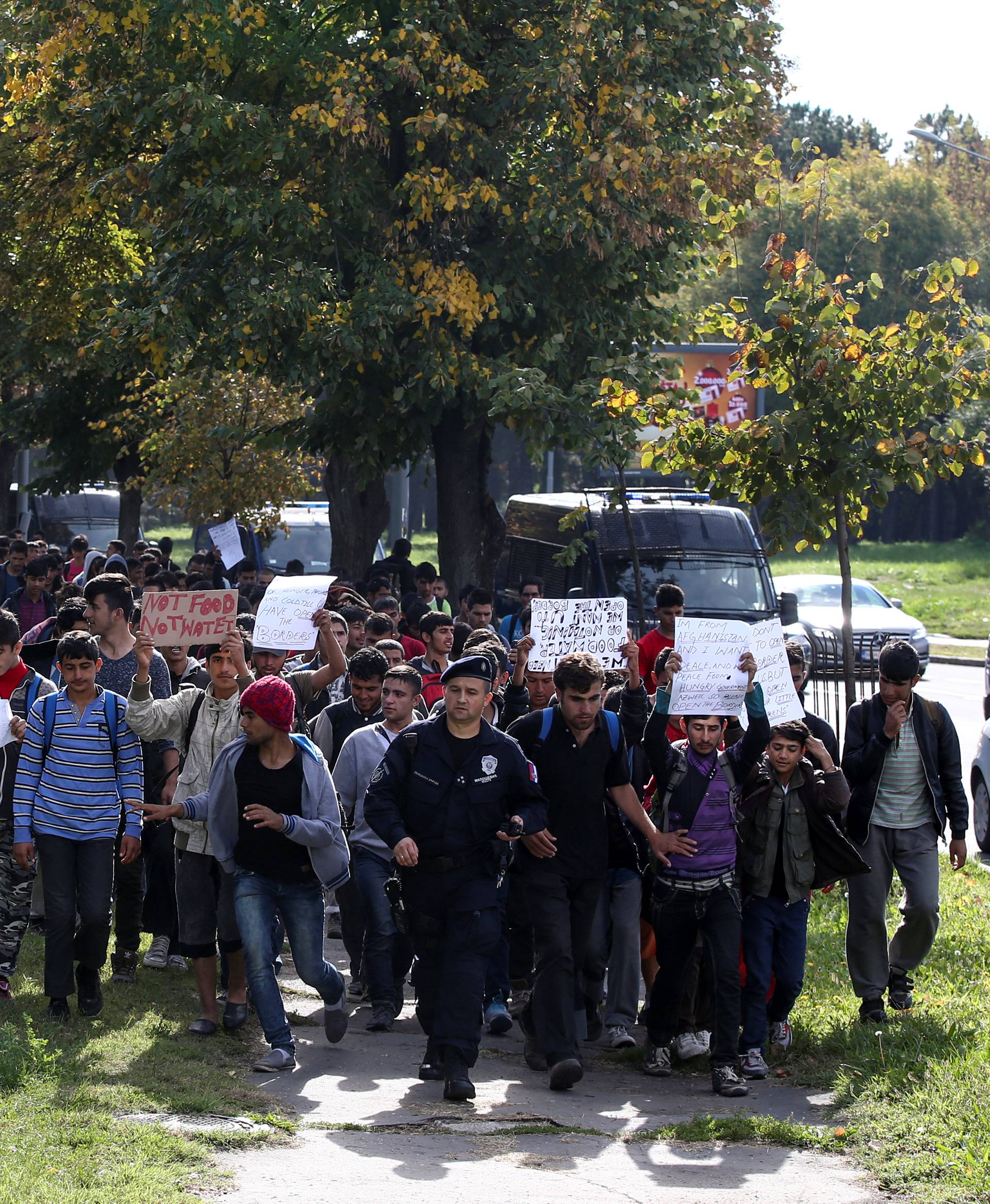 Several hundred refugees and migrants walk heading in the direction of the Hungarian border in Belgrade