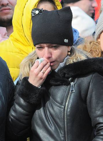 People mourn the victims of a shopping mall fire at a makeshift memorial in Kemerovo