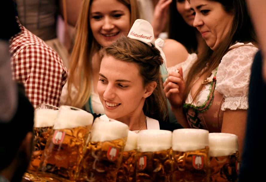A waitress carries mugs of beer during the opening day of the 185th Oktoberfest in Munich