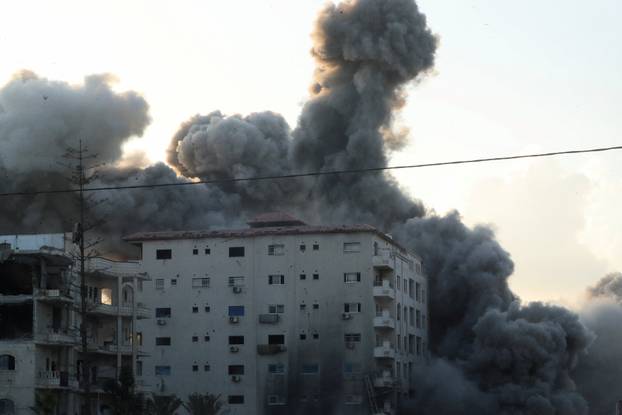 Smoke and flames rise as a residential building collapses after an Israeli air strike, in Gaza City