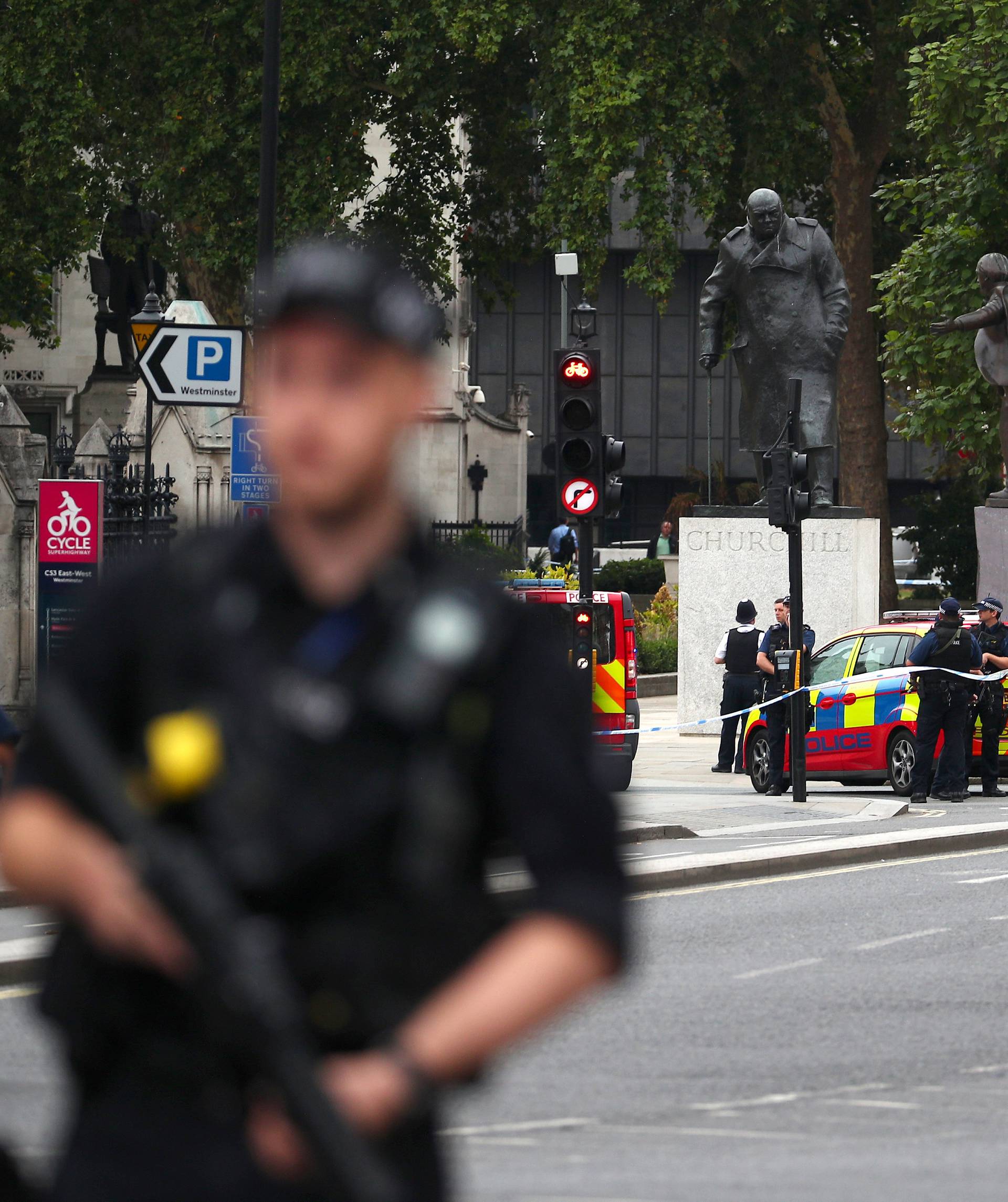 Armed police stand in the street after a car crashed outside the Houses of Parliament in Westminster, London