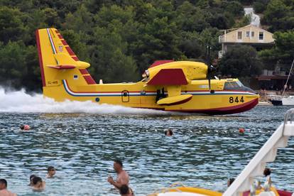 Turisti s plaže u Grebaštici s neposredne blizine promatrali kanadere kako uzimaju vodu za gašenje požara