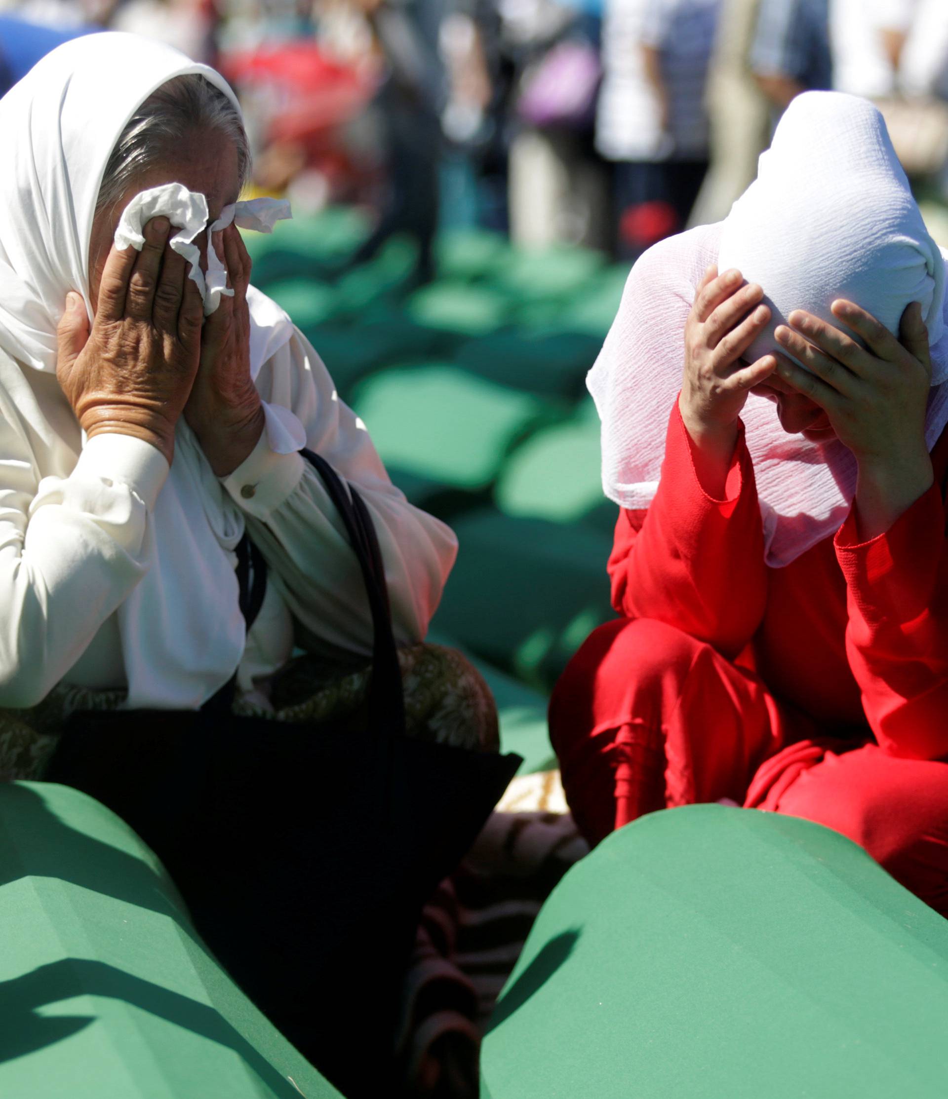 Muslim women cry near coffins of their relatives, who are newly identified victims of the 1995 Srebrenica massacre, which are lined up for a joint burial in Potocari near Srebrenica