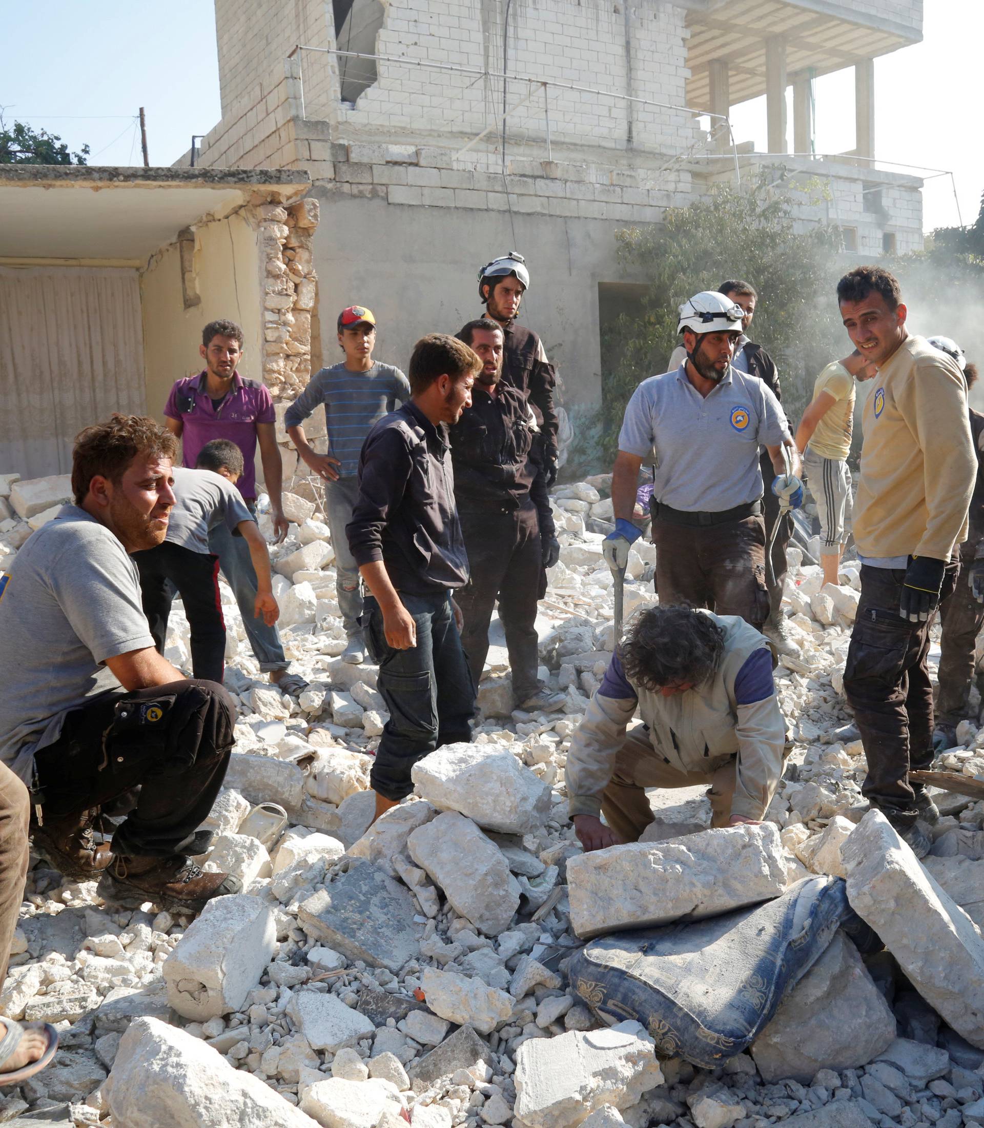 Men and civil defence members look for survivors after an airstrike on a hospital in the town of Meles, western Idlib city in rebel-held Idlib province
