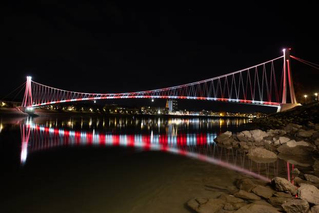 Osijek: Pješački most osvijetljen crveno bijelom  bojom povodom Dana sjećanja na žrtvu Vukovara i Škabrnje