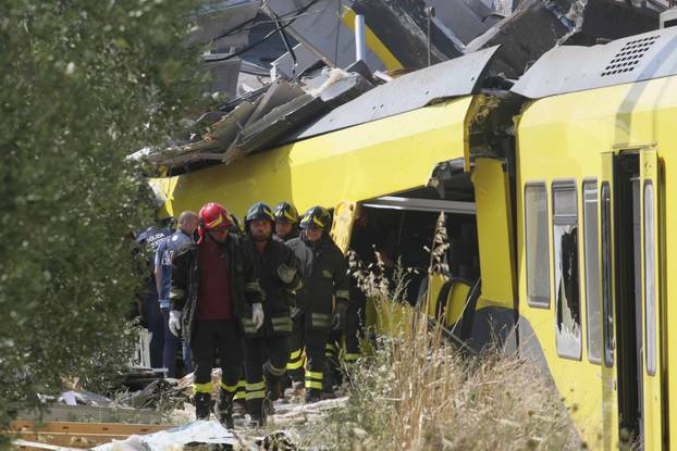 Firefighters work in the area where two passenger trains collided in the middle of an olive grove in the southern village of Corato