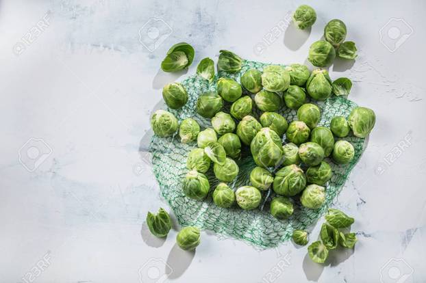 Bunch of fresh Bruxelles sprouts in a cup on background