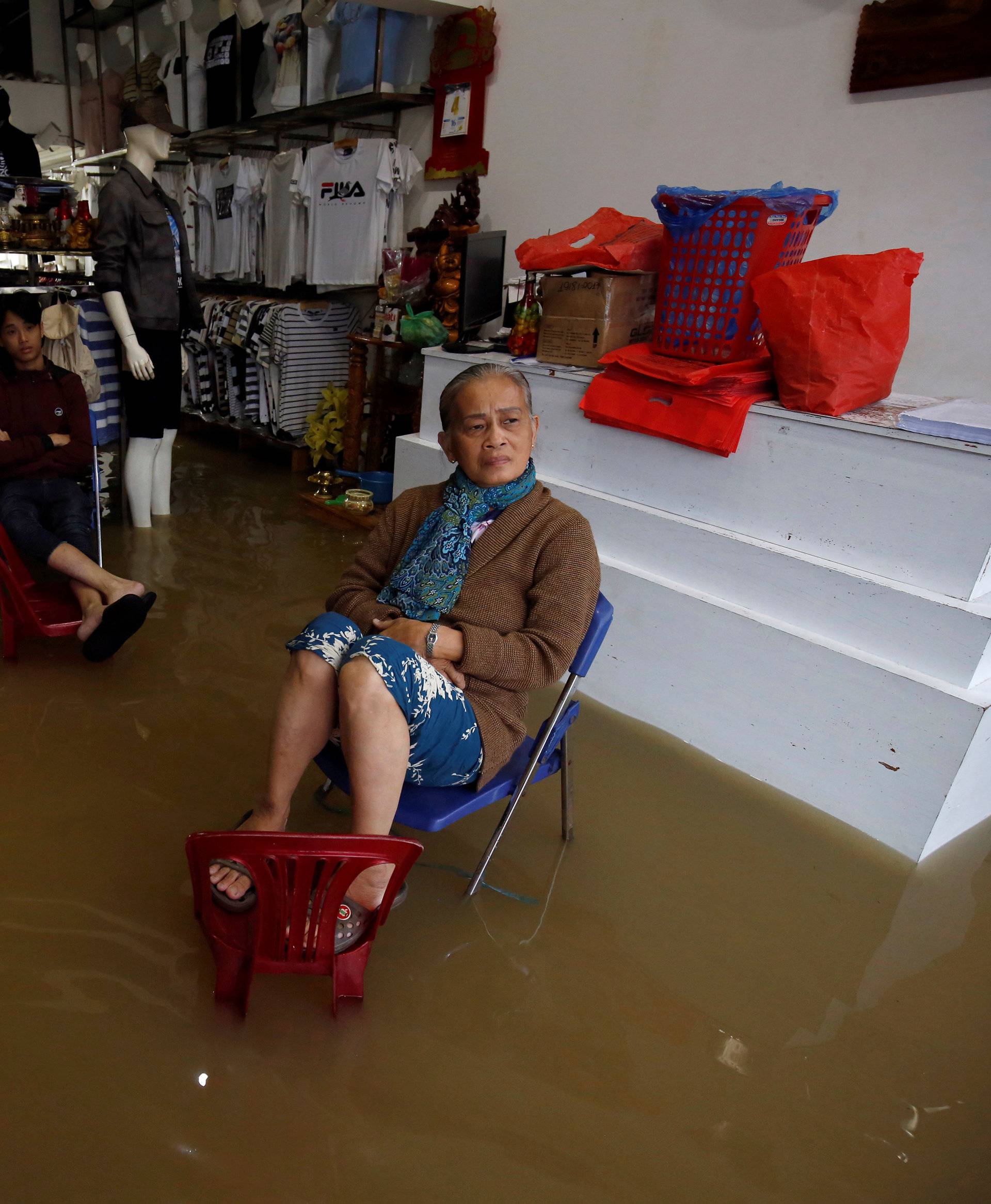 Residents sit on their flooded fashion shop after typhoon Damrey hits Vietnam in Hue city