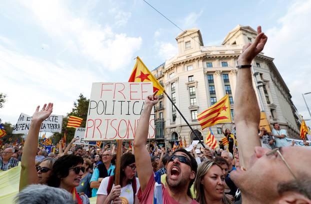 Protesters react to a police helicopter flying overhead during a demonstration organised by Catalan pro-independence movements ANC (Catalan National Assembly) and Omnium Cutural, following the imprisonment of their two leaders, in