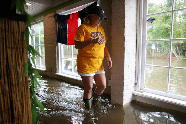 Robyn Iacona-Hilbert walks through her flooded business after Hurricane Barry in Mandeville