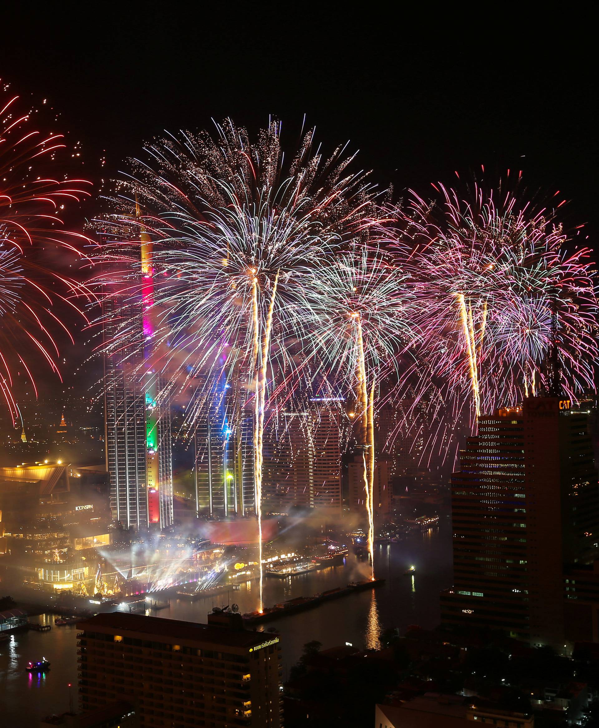 Fireworks explode over Chao Phraya River during the New Year celebrations in Bangkok